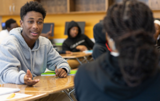 Teen boy at desk talking animatedly