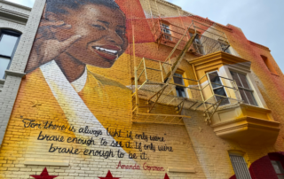 Photo of DC street mural with picture of Amanda Gorman and quote from The Hill We Climb